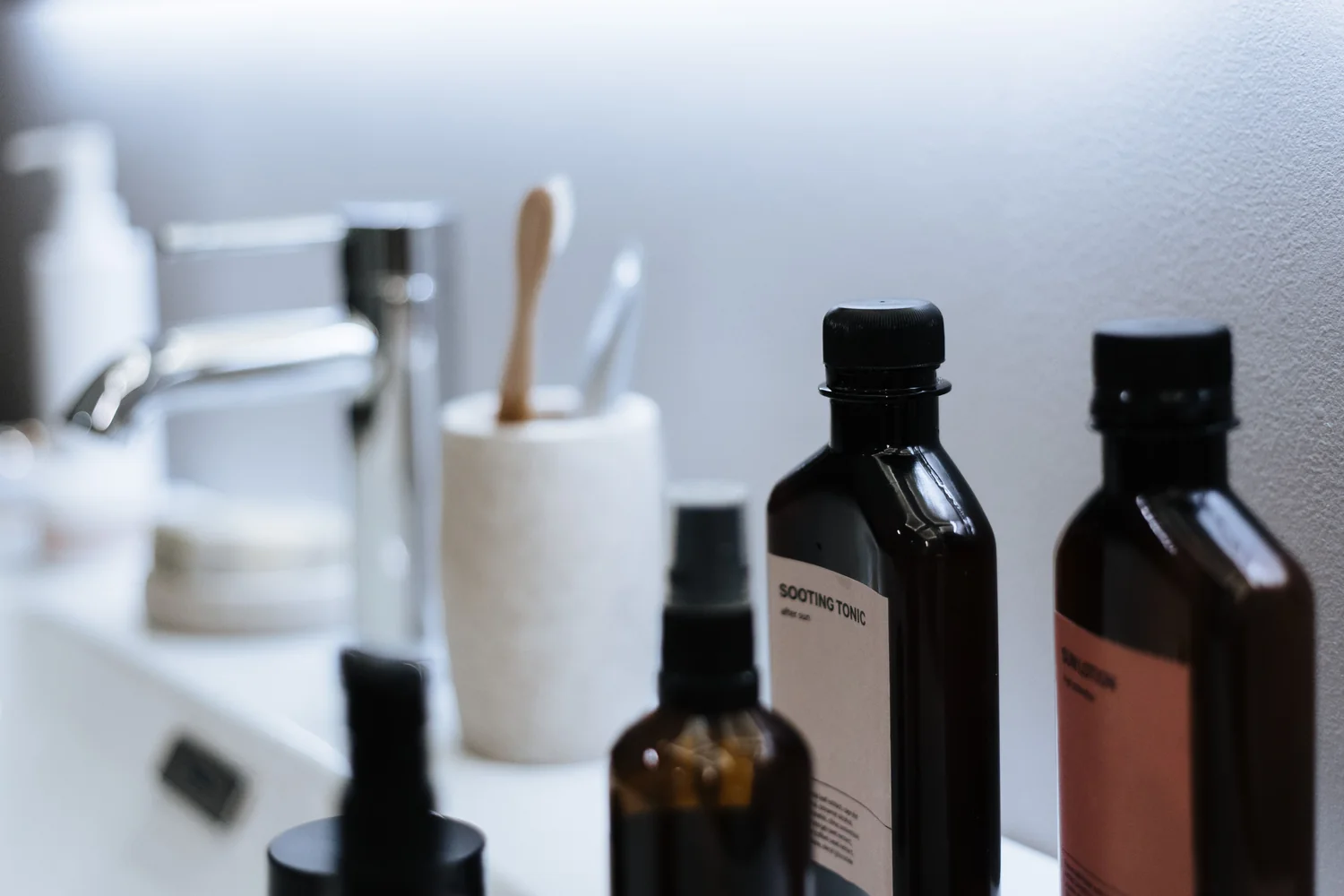 Productos de belleza e higiene personal en un lavabo de líneas limpias.